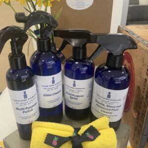 Blue bottles of cleaning solutions with yellow sponges on a table.